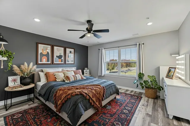 a bed sitting in a spacious bedroom next to a window