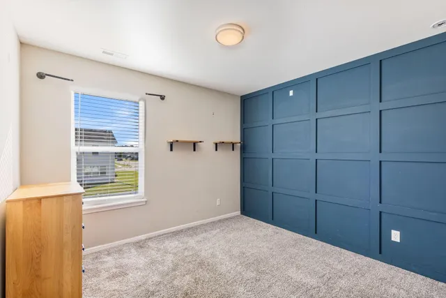 a view of an empty room with cabinet and window