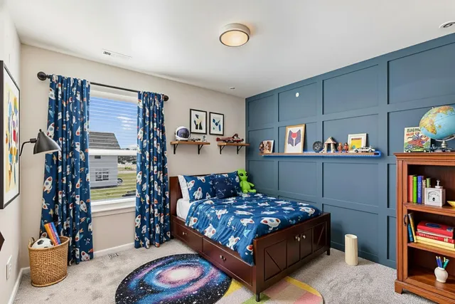 a bedroom with a bed bookshelf and a window