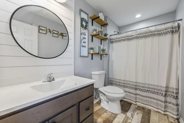 a bathroom with a sink a toilet and a mirror