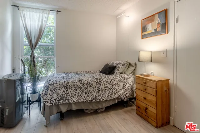 a bedroom with a bed and a lamp on dresser