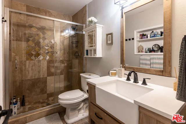 a bathroom with a sink a toilet and shower