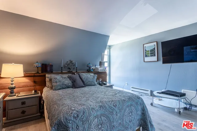 a bedroom with a bed and flat screen tv