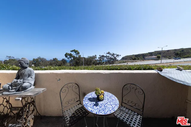 an outdoor sitting area with furniture and kitchen view