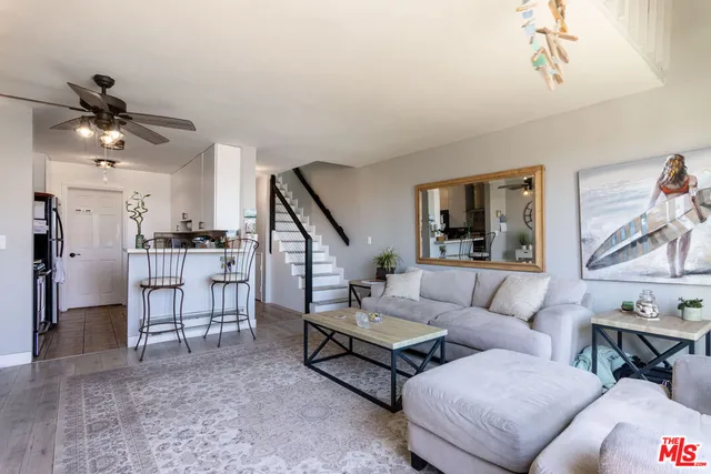 a living room with furniture and a dining table with kitchen view