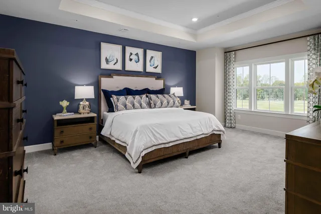 a bedroom with a bed a couch and a large window