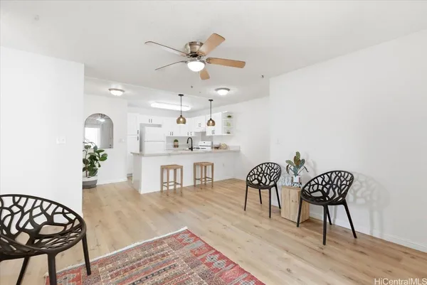a dining room with wooden floor and a chandelier