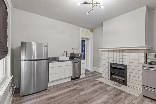 a kitchen with a refrigerator a stove and wooden floor