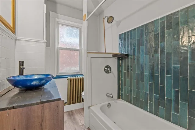 a bathroom with a granite countertop sink a toilet and shower