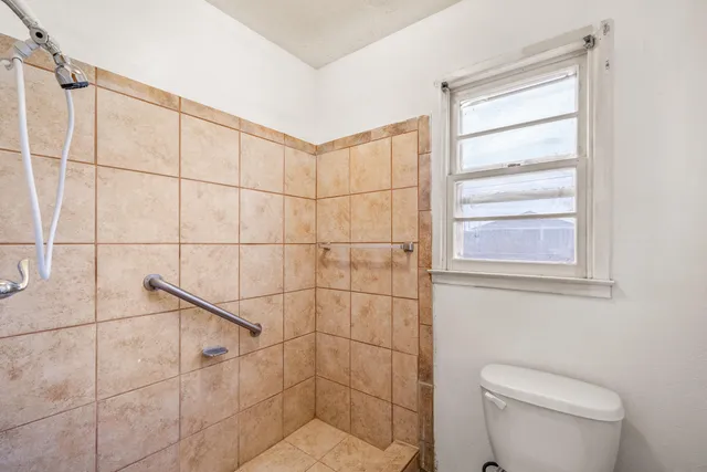 a bathroom with a toilet and a shower