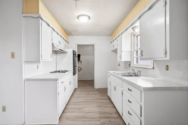 a kitchen with granite countertop a sink and a refrigerator