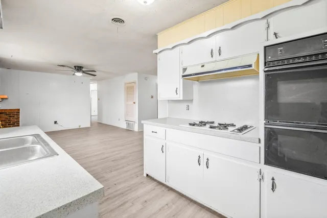 a kitchen with white cabinets and appliances