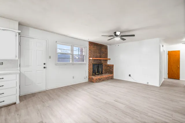 an empty room with cabinet and windows