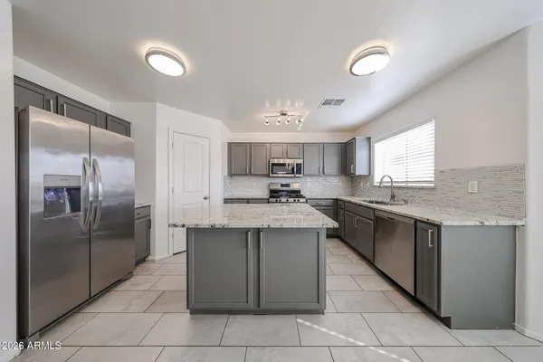 a kitchen with stainless steel appliances granite countertop a refrigerator and a sink
