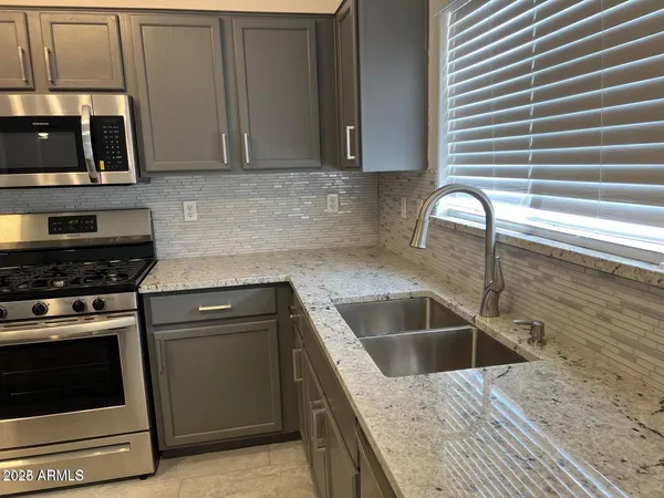 a kitchen with a sink stove and cabinets