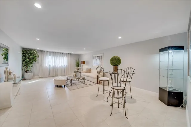 a living room with furniture and potted plants