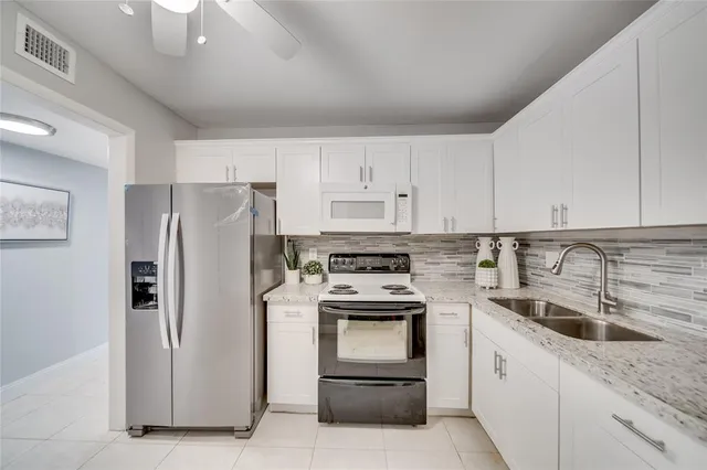a kitchen with a refrigerator stove and white cabinets