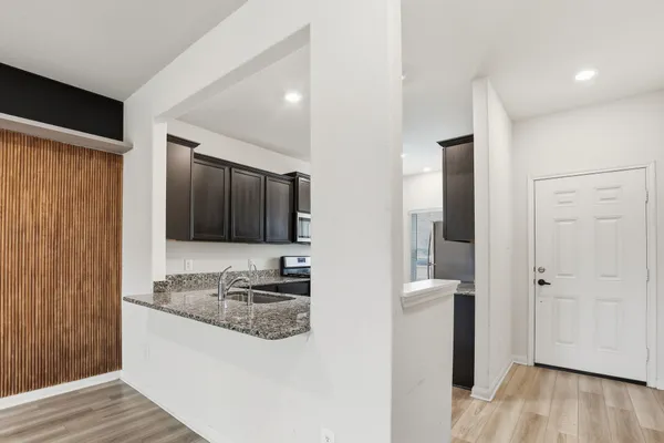 a kitchen with stainless steel appliances granite countertop a sink stove and refrigerator