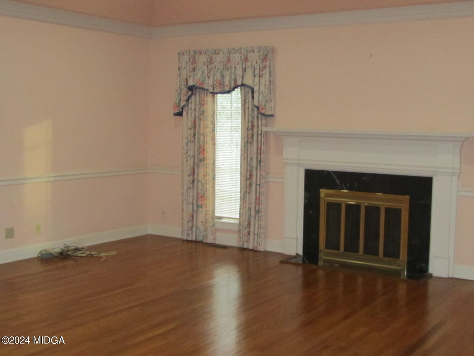 760 Bass Road Macon, GA 31210 - Photo 20 of 44 an empty room with wooden floor a fireplace and windows