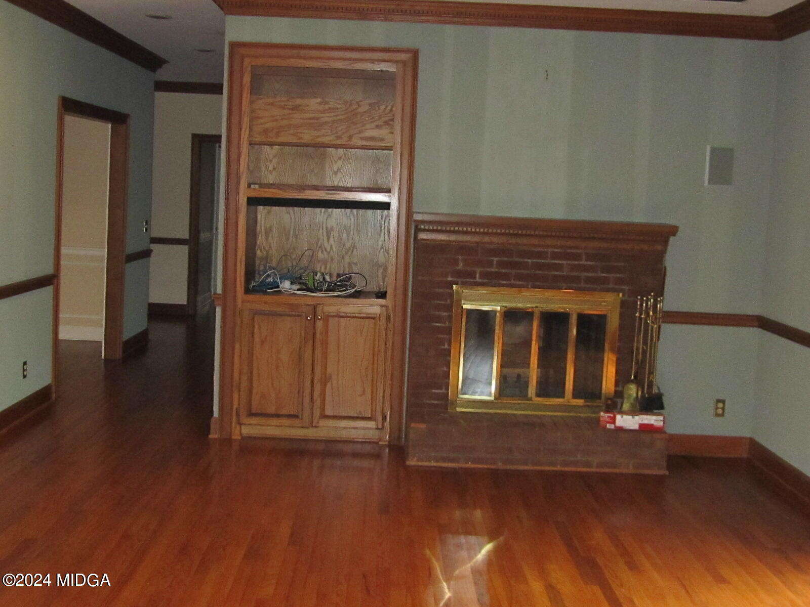 760 Bass Road Macon, GA 31210 - Photo 5 of 44 an empty room with wooden floor a fireplace and windows