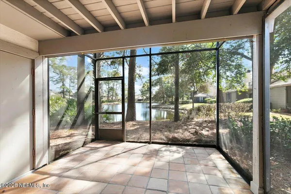 a view of empty room with wooden floor and floor to ceiling window