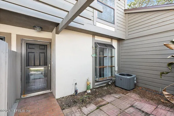 a view of a porch with a door and wooden bench