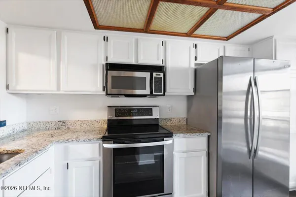 a kitchen with stainless steel appliances granite countertop a refrigerator stove and microwave