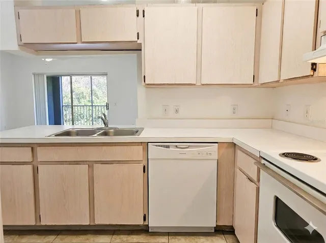 a kitchen with white cabinets sink and white appliances