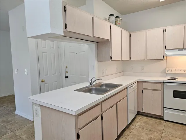 a kitchen with a refrigerator sink and cabinets