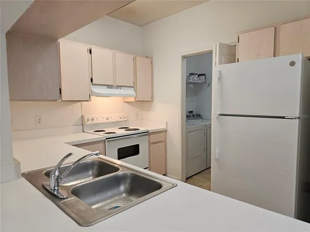 a white refrigerator freezer and a stove sitting inside of a kitchen