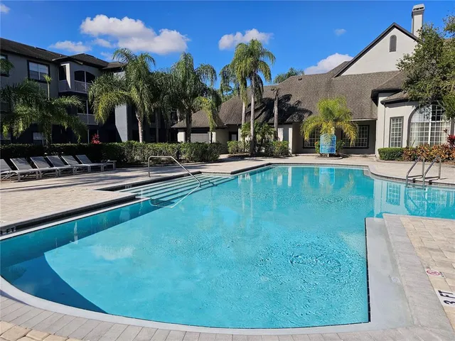 a view of a house with swimming pool and sitting area