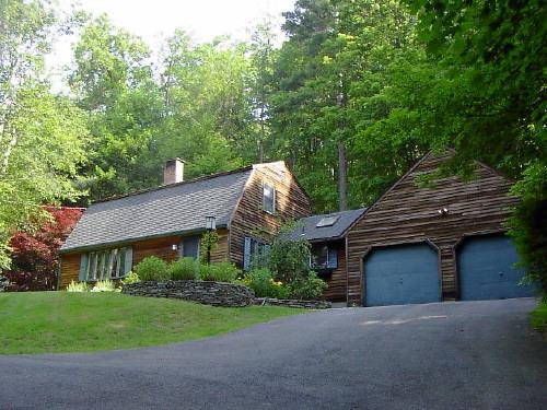 a front view of a house with a garden and plants