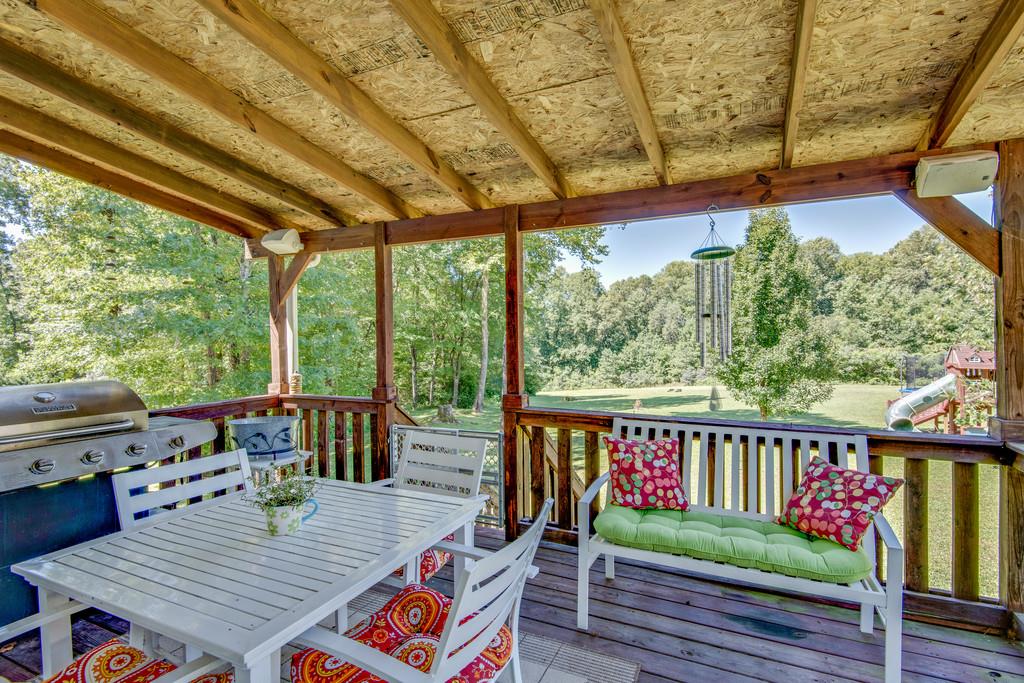 1006 Meeks Cemetery Road Burns, TN 37029 - Photo 17 of 19 a view of a patio with couches chairs potted plants and wooden floor
