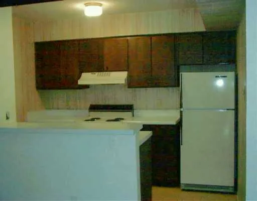 a kitchen with a refrigerator and a stove