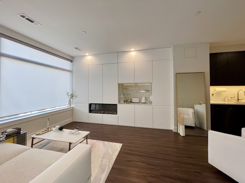 99 Sumner Street, Unit 306 Boston, MA 02128 - Photo 3 of 15 a living room with furniture and a flat screen tv