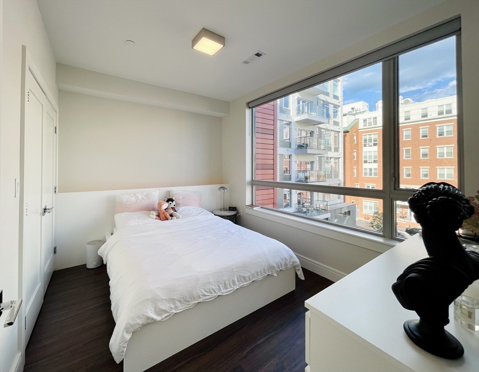 99 Sumner Street, Unit 306 Boston, MA 02128 - Photo 6 of 15 a bedroom with a bed and a large window