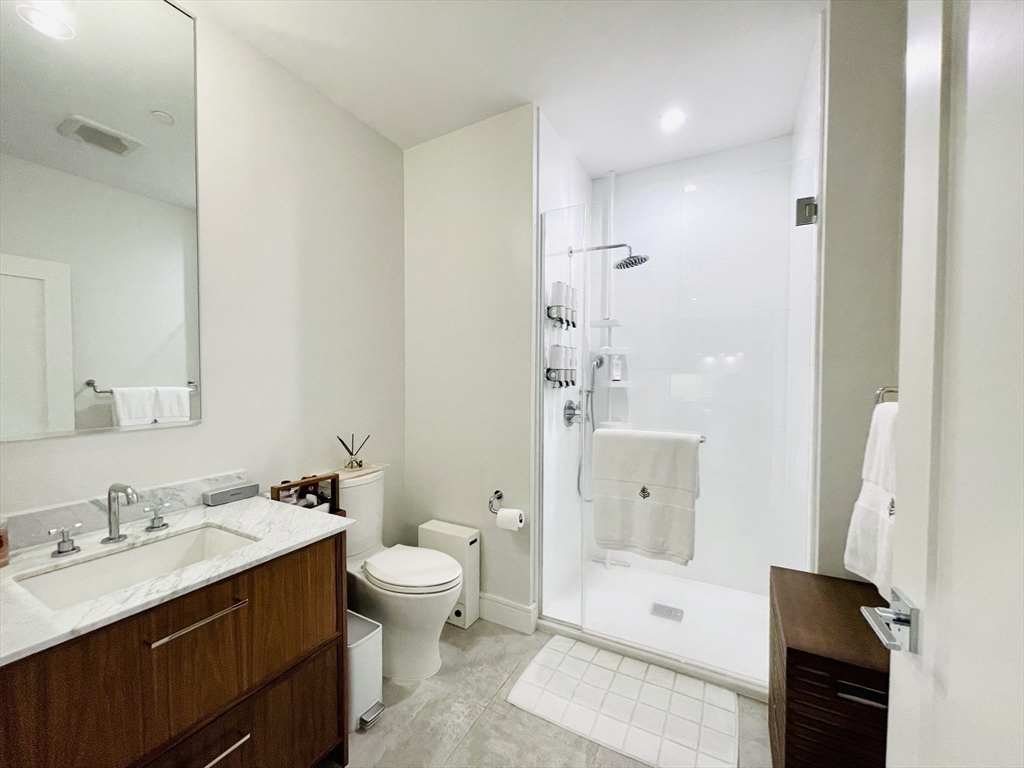 99 Sumner Street, Unit 306 Boston, MA 02128 - Photo 8 of 15 a bathroom with a double vanity sink toilet and shower