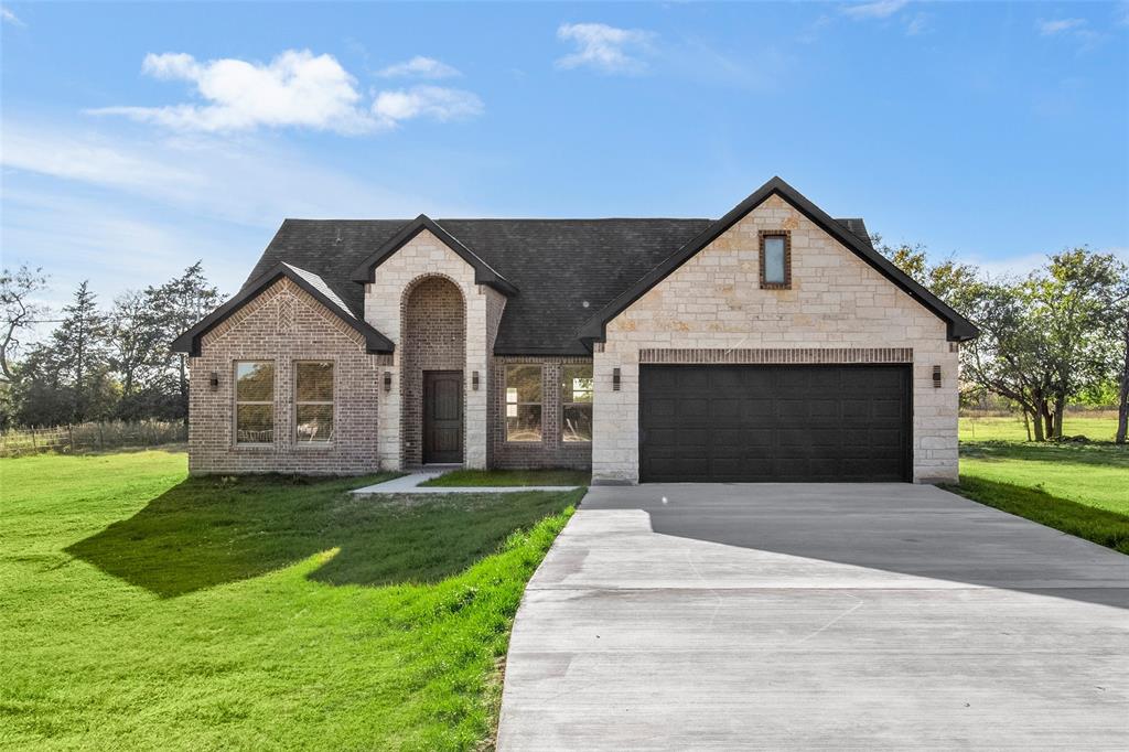 a front view of a house with a yard and garage