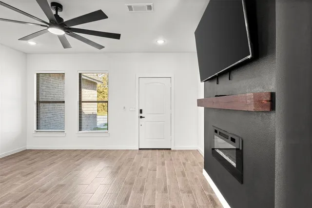 a view of an empty room with a window and a fireplace