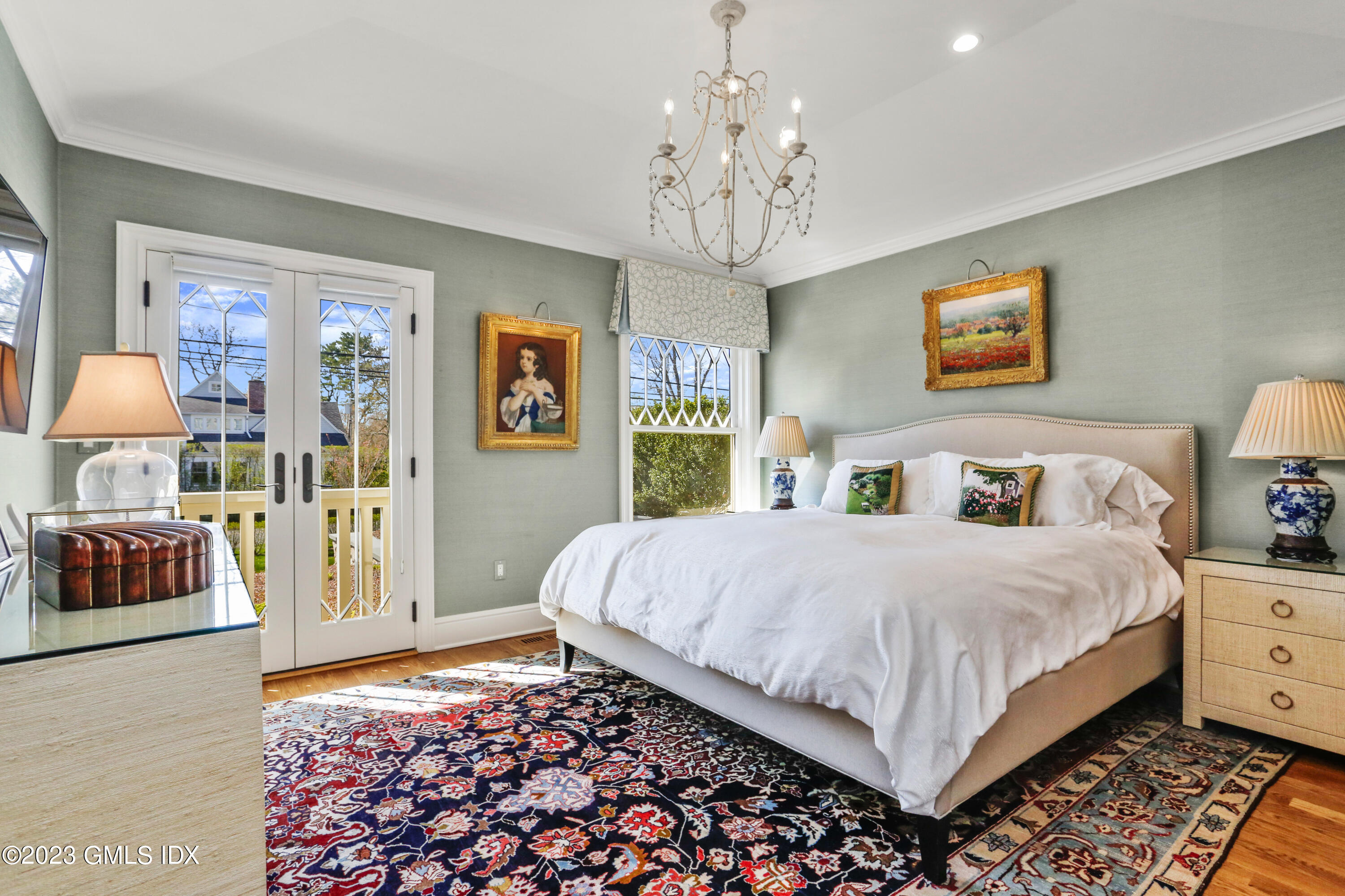 165 Shore Road, Unit A Old Greenwich, CT 06870 - Photo 11 of 28 a bedroom with a large bed and a chandelier