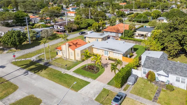 an aerial view of a residential houses with yard