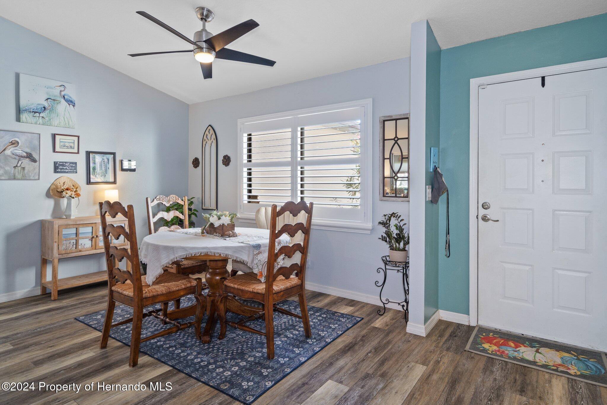 7427 Heather Walk Drive Spring Hill, FL 34613 - Photo 11 of 36 a view of a dining room with furniture and wooden floor