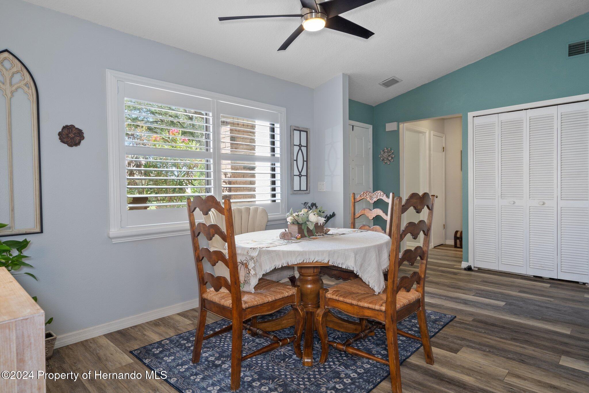 7427 Heather Walk Drive Spring Hill, FL 34613 - Photo 12 of 36 a view of a dining room with furniture window and wooden floor