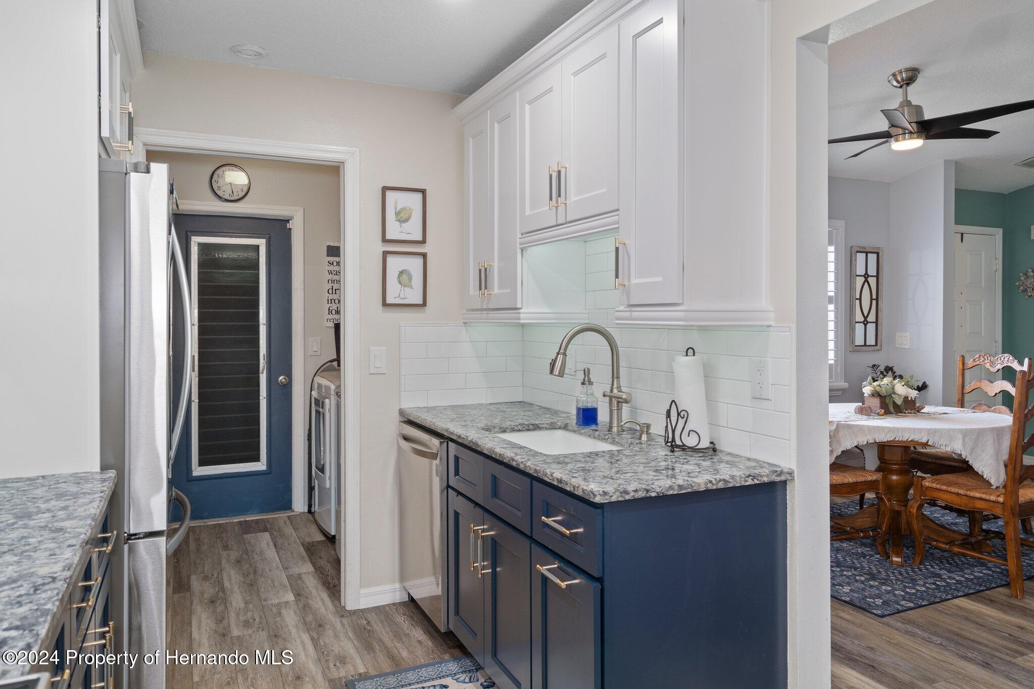 7427 Heather Walk Drive Spring Hill, FL 34613 - Photo 19 of 36 a kitchen with stainless steel appliances granite countertop a sink and dishwasher with wooden cabinets