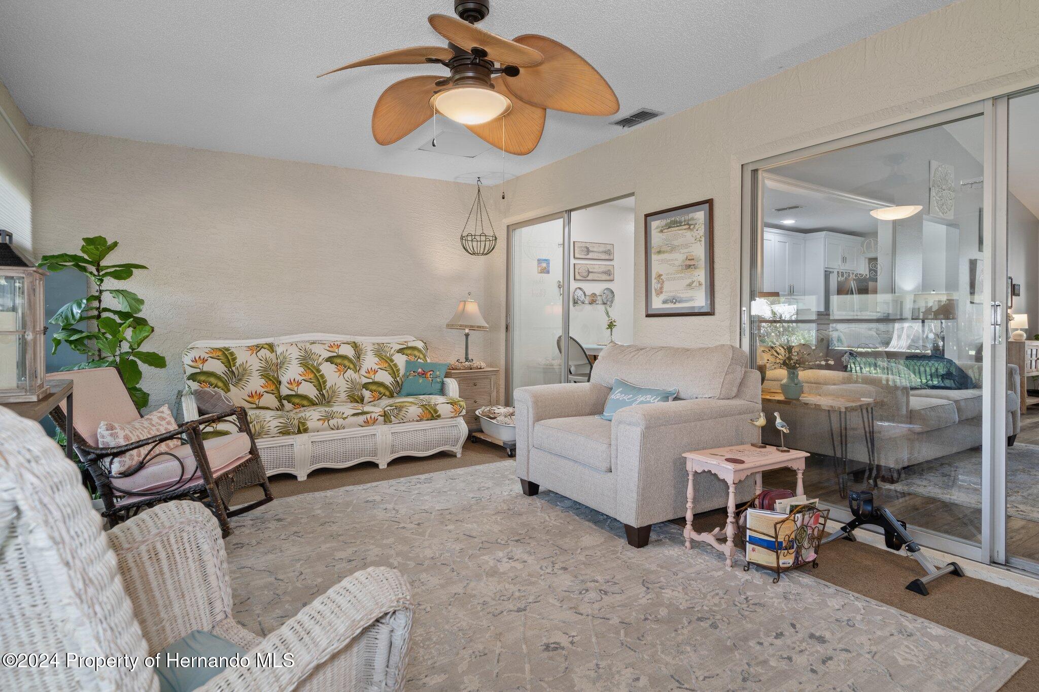 7427 Heather Walk Drive Spring Hill, FL 34613 - Photo 23 of 36 a living room with furniture and a chandelier
