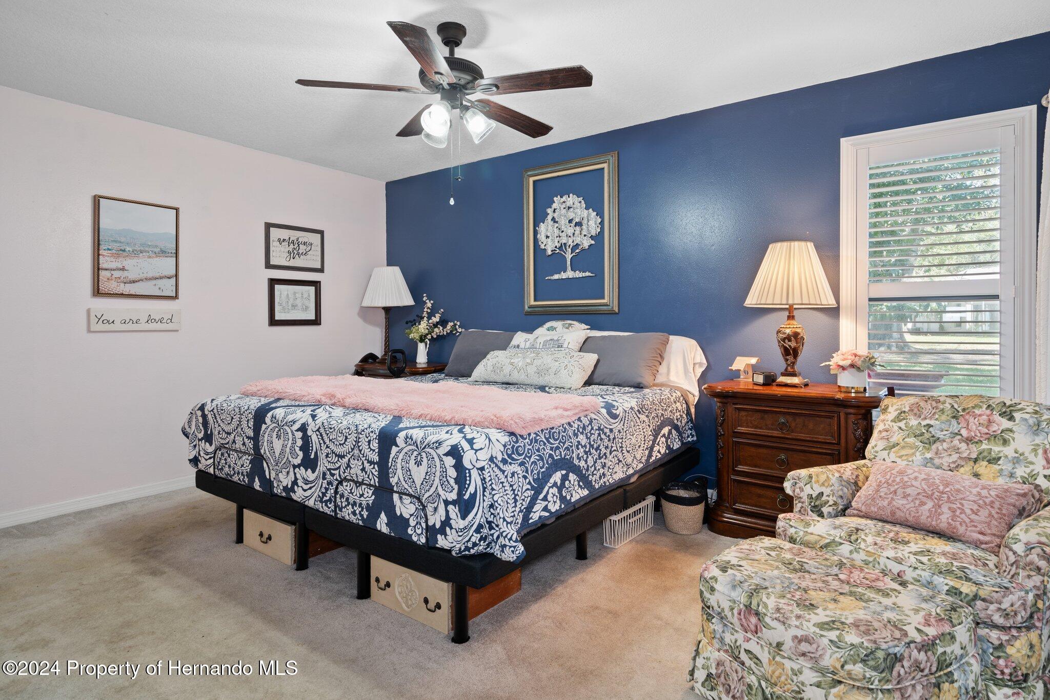 7427 Heather Walk Drive Spring Hill, FL 34613 - Photo 24 of 36 a bedroom with a bed and a chandelier