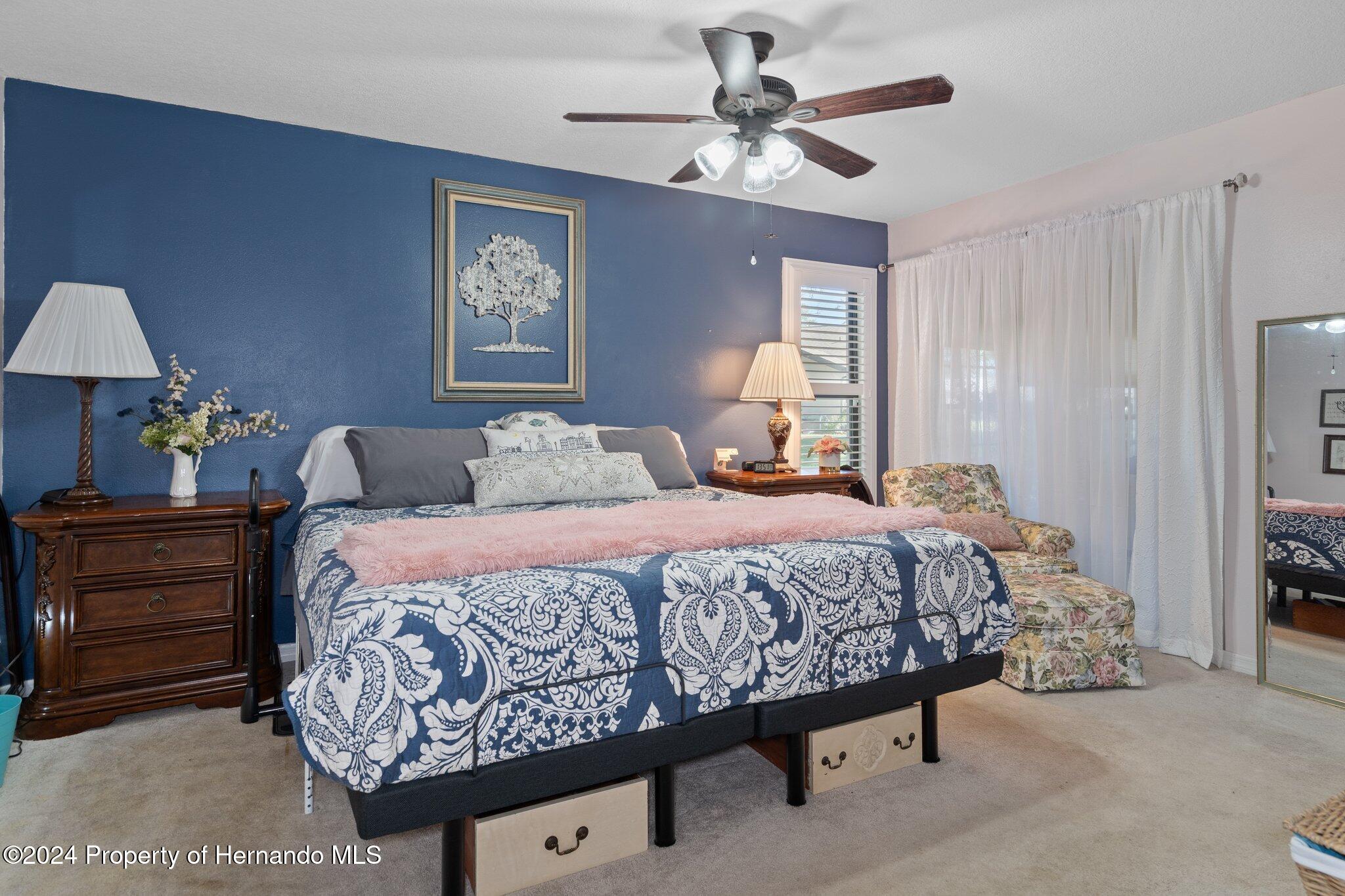 7427 Heather Walk Drive Spring Hill, FL 34613 - Photo 25 of 36 a bedroom with a bed and a chandelier