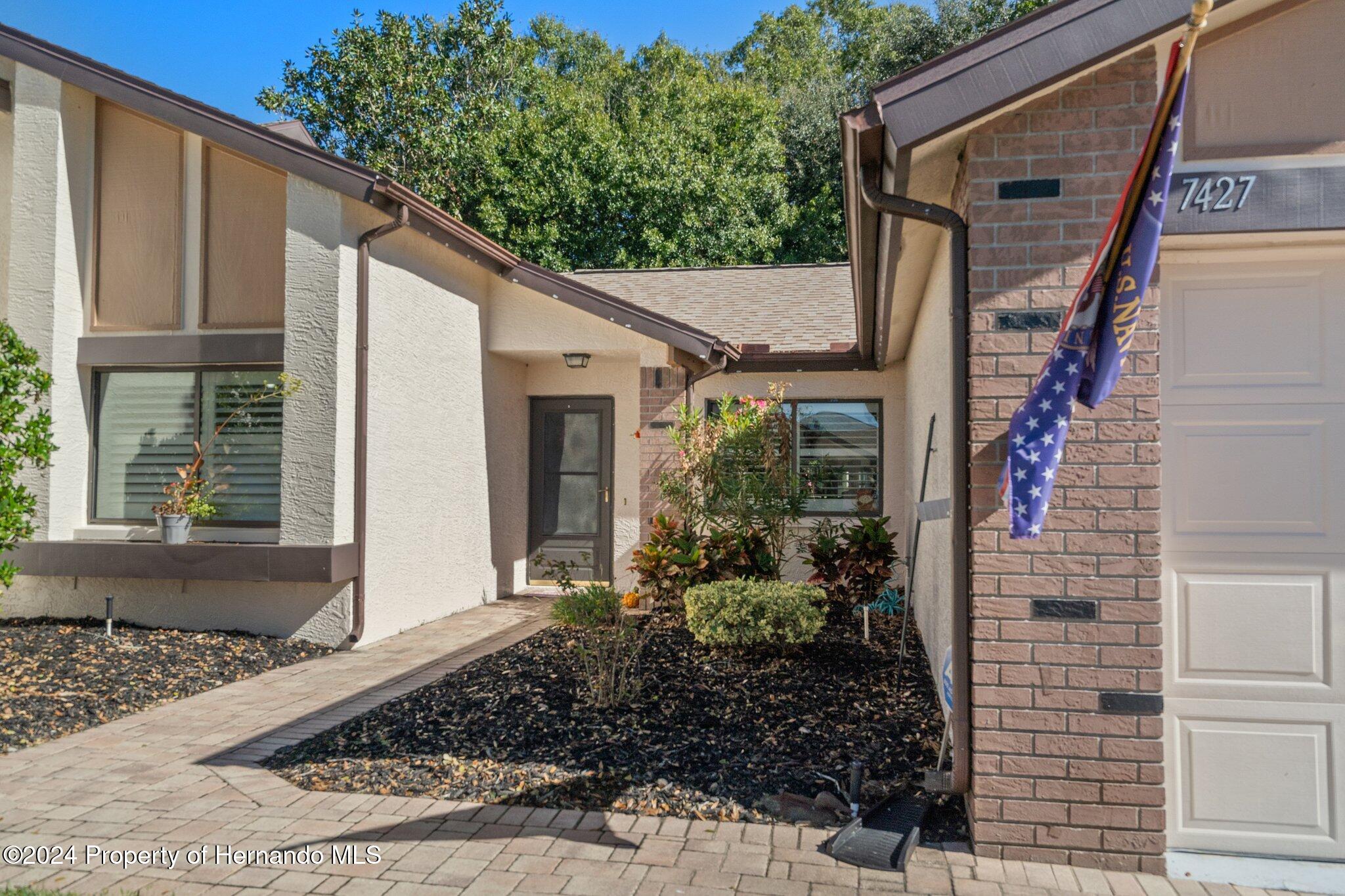 7427 Heather Walk Drive Spring Hill, FL 34613 - Photo 8 of 36 a front view of a house with garden