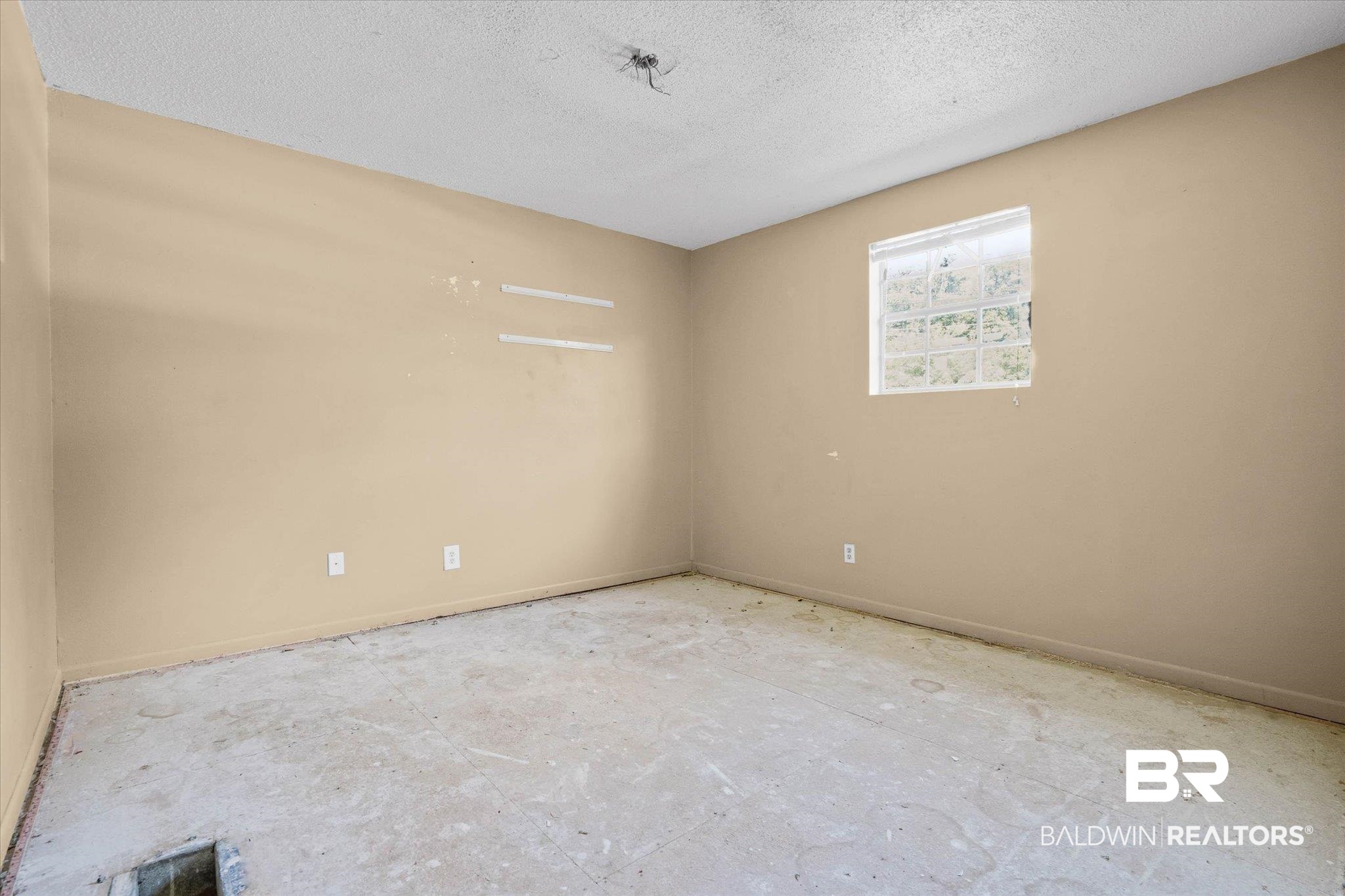 401 Frederick Avenue Fairhope, AL 36532 - Photo 11 of 36 Room with neutral-toned walls, a textured ceiling, and a glass block window