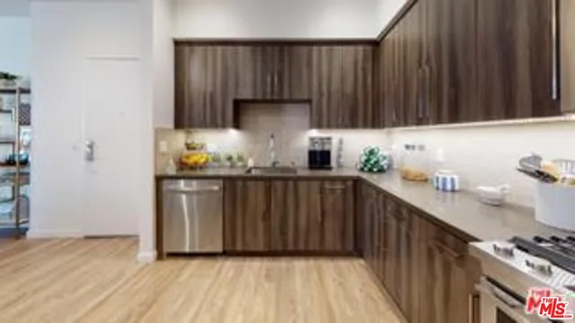 a kitchen with granite countertop a sink stove and cabinets